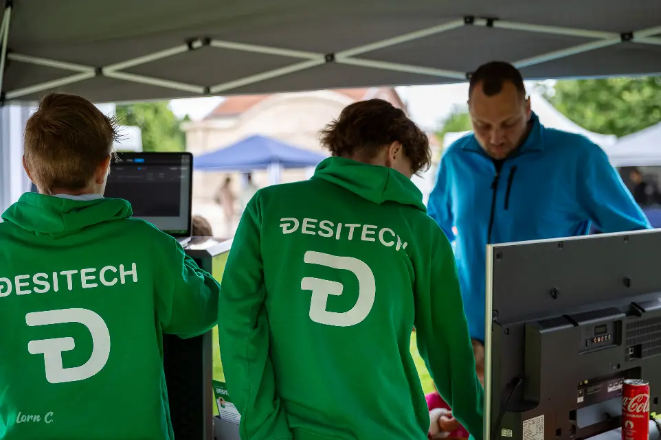 L'équipe DESITECH sur un stand, en tenue floquée, présentant son matériel